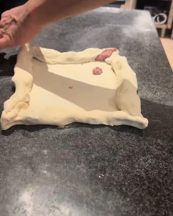 Il bordo ripieno: L'impasto si stende e il bordo si chiude su salsiccia e ricotta.