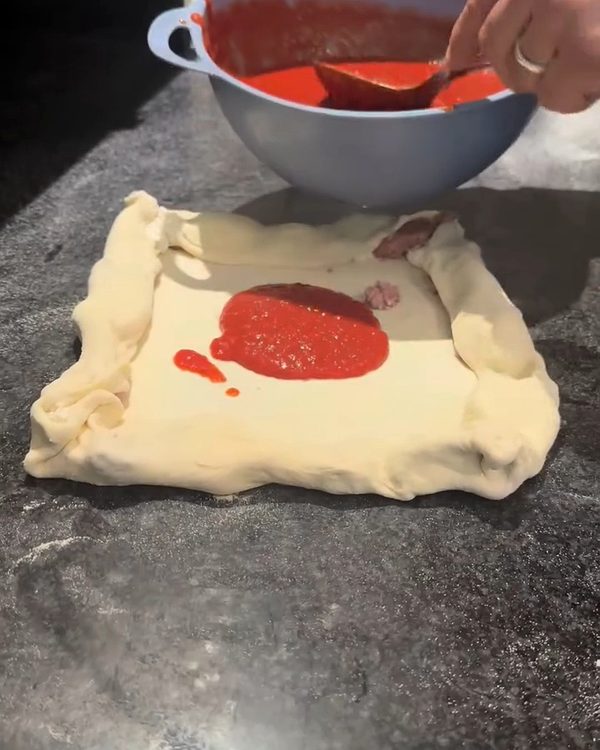 Il pomodoro: Poi il pomodoro, steso a cucchiaiate fino al bordo.