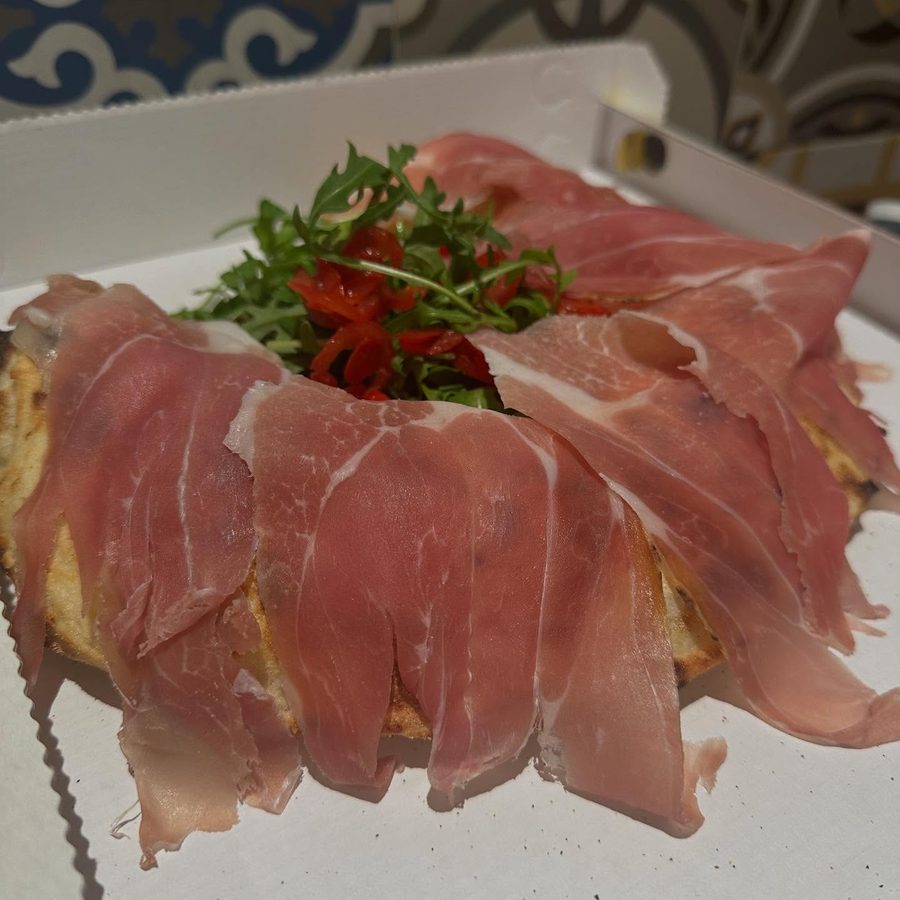 Il Cornetto di bufala coperto di prosciutto crudo, con rucola e pomodorini al centro